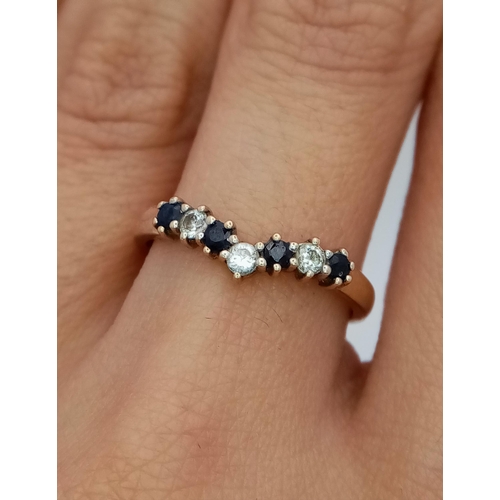 571 - A 9K Yellow Gold Sapphire and White Zircon Chevron Ring. Size M. 1.5g total weight.