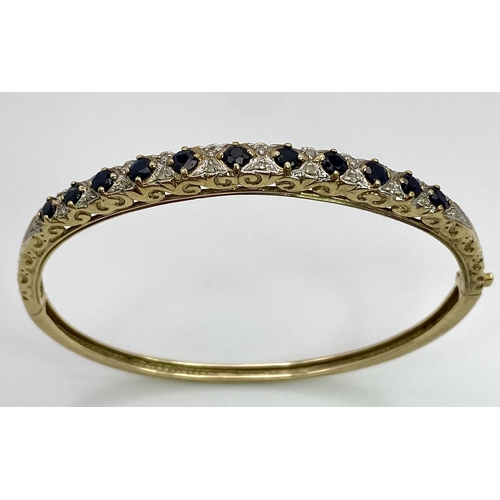 40 - A 9K YELLOW GOLD DIAMOND & SAPPHIRE SET BANGLE 10.4G , 55mm x 63mm diameter.

SC 9005