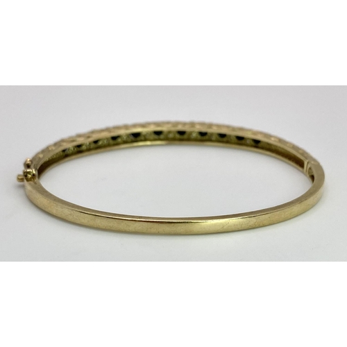 40 - A 9K YELLOW GOLD DIAMOND & SAPPHIRE SET BANGLE 10.4G , 55mm x 63mm diameter.

SC 9005