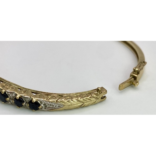 40 - A 9K YELLOW GOLD DIAMOND & SAPPHIRE SET BANGLE 10.4G , 55mm x 63mm diameter.

SC 9005