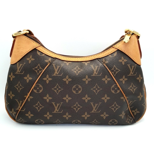 130 - A Louis Vuitton Thames Shoulder Bag. Monogramed canvas exterior with gold-toned hardware, adjustable... 