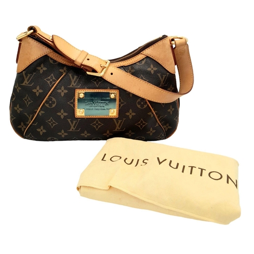 130 - A Louis Vuitton Thames Shoulder Bag. Monogramed canvas exterior with gold-toned hardware, adjustable... 