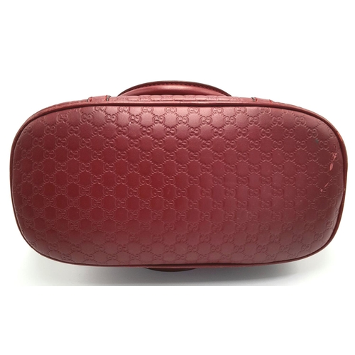 208 - A Gucci Red Guccissima Dome Bag. Monogramed leather exterior with gold-toned hardware, two rolled le... 