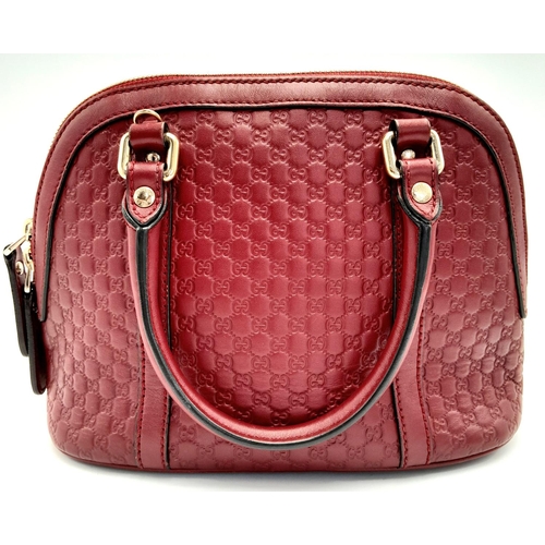 208 - A Gucci Red Guccissima Dome Bag. Monogramed leather exterior with gold-toned hardware, two rolled le... 