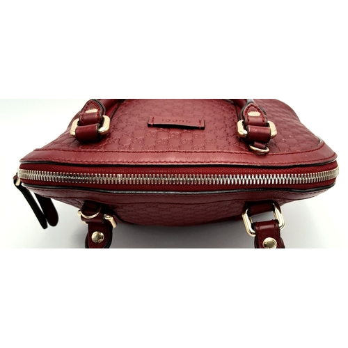 208 - A Gucci Red Guccissima Dome Bag. Monogramed leather exterior with gold-toned hardware, two rolled le... 