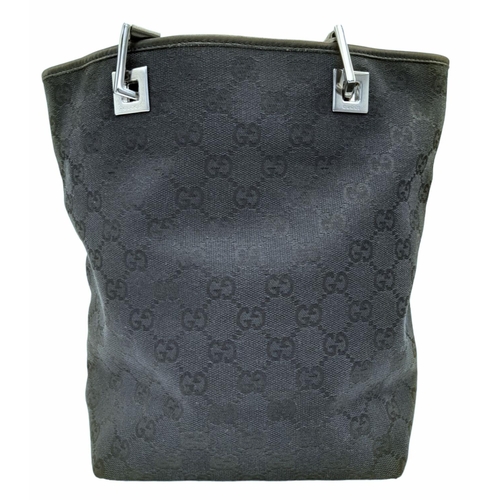 331 - A Gucci Black Monogram Tote Bag. Canvas exterior with leather trim, two leather straps and silver-to... 