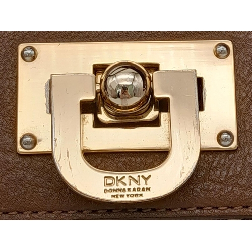 358 - A DKNY Brown Satchel Bag. Canvas and leather exterior with gold-toned hardware, four protective base... 