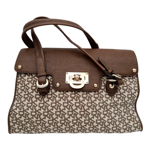 358 - A DKNY Brown Satchel Bag. Canvas and leather exterior with gold-toned hardware, four protective base... 