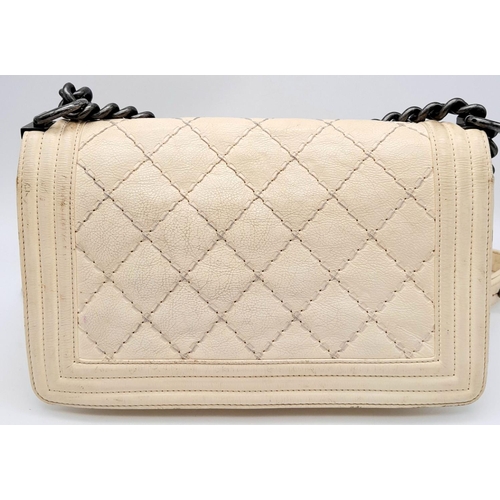 93 - A Chanel Ivory Boy Bag. Leather exterior with chrome-toned hardware, chain and leather strap, and sq... 