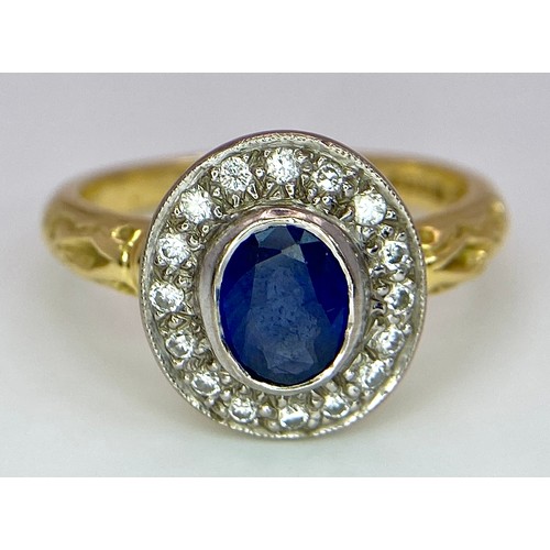 267 - An 18 K yellow gold ring with an oval cut blue sapphire surrounded by a halo of round cut diamonds a... 