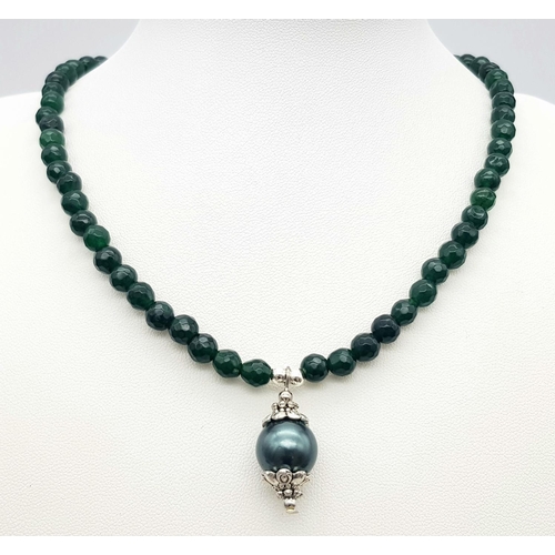 992 - A Small Emerald Beaded Necklace with Hanging Shell Pendant. 36cm necklace. 2.5cm pendant.