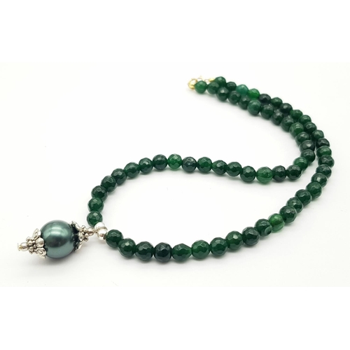 992 - A Small Emerald Beaded Necklace with Hanging Shell Pendant. 36cm necklace. 2.5cm pendant.