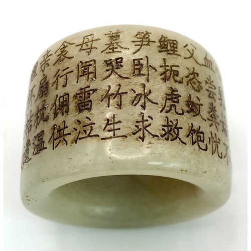 231 - An antique Chinese white nephrite jade “thumb” ring, or amulet, with a Buddhist prayer engraved arou... 