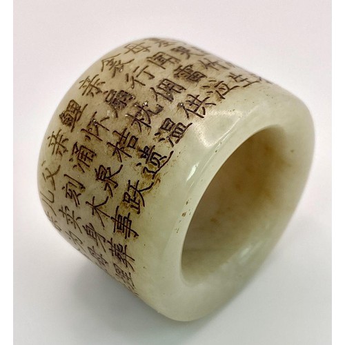 231 - An antique Chinese white nephrite jade “thumb” ring, or amulet, with a Buddhist prayer engraved arou... 