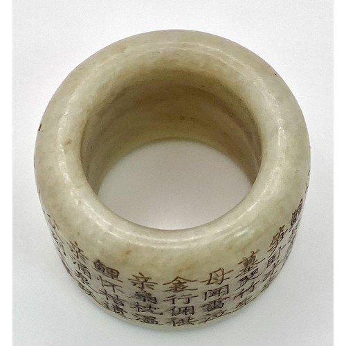 231 - An antique Chinese white nephrite jade “thumb” ring, or amulet, with a Buddhist prayer engraved arou... 