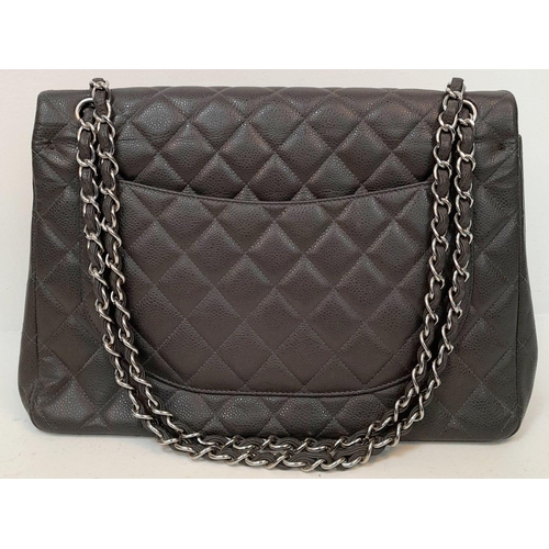 129 - A Chanel Jumbo Double Flap Maxi Bag. Dark grey quilted caviar leather exterior with a large slip poc... 