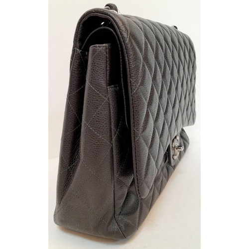 129 - A Chanel Jumbo Double Flap Maxi Bag. Dark grey quilted caviar leather exterior with a large slip poc... 