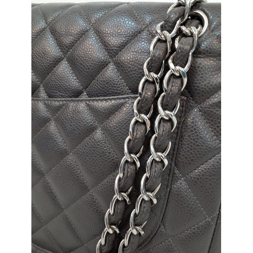 129 - A Chanel Jumbo Double Flap Maxi Bag. Dark grey quilted caviar leather exterior with a large slip poc... 