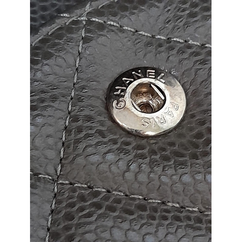129 - A Chanel Jumbo Double Flap Maxi Bag. Dark grey quilted caviar leather exterior with a large slip poc... 