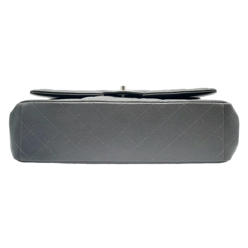 129 - A Chanel Jumbo Double Flap Maxi Bag. Dark grey quilted caviar leather exterior with a large slip poc... 