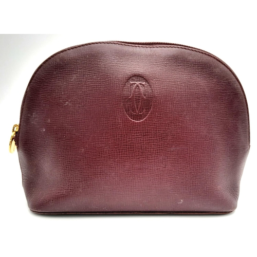 170 - A Vintage Cartier Burgundy Pouch. Leather exterior with zip top closure. Burgundy canvas interior. A... 