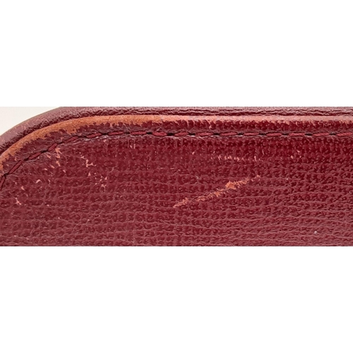 170 - A Vintage Cartier Burgundy Pouch. Leather exterior with zip top closure. Burgundy canvas interior. A... 