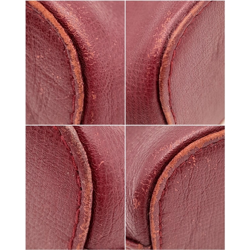 170 - A Vintage Cartier Burgundy Pouch. Leather exterior with zip top closure. Burgundy canvas interior. A... 