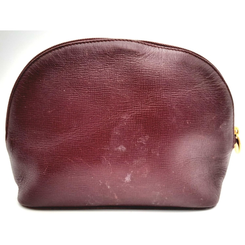 170 - A Vintage Cartier Burgundy Pouch. Leather exterior with zip top closure. Burgundy canvas interior. A... 