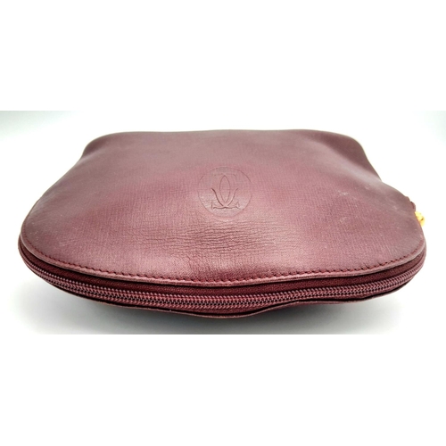 170 - A Vintage Cartier Burgundy Pouch. Leather exterior with zip top closure. Burgundy canvas interior. A... 