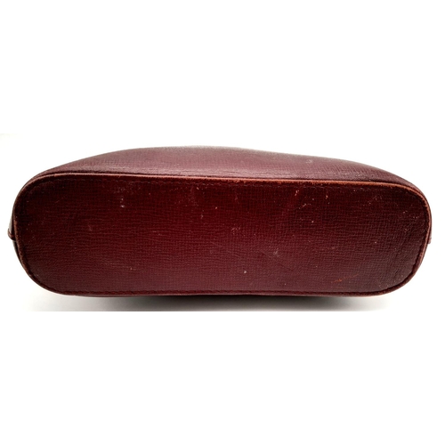 170 - A Vintage Cartier Burgundy Pouch. Leather exterior with zip top closure. Burgundy canvas interior. A... 