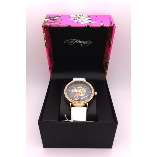 1373 - An Ed Hardy Ladies Quartz Watch. As new, in original packaging but needs a battery so as found.