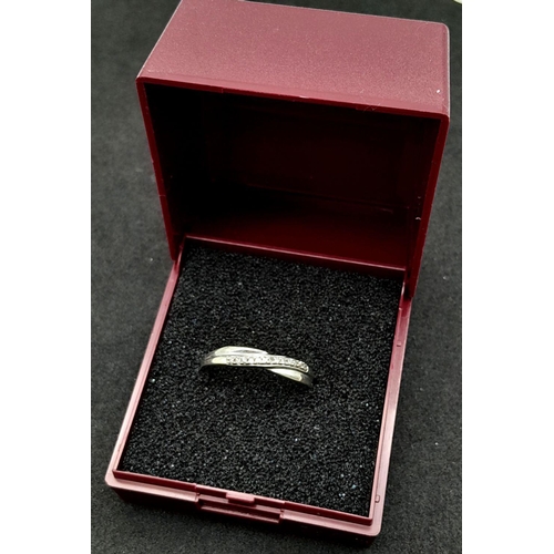 14 - Hallmarked 9 carat DIAMOND SET WHITE GOLD CROSSOVER RING. 1.17 grams. Size O - O 1/2.