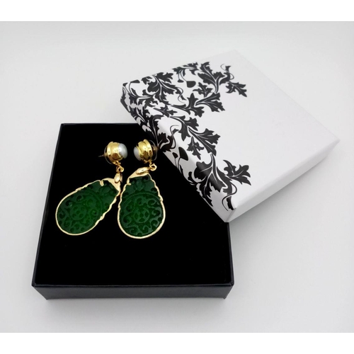 210 - A gilded, fashionable, carved green jade pair of earrings, length: 6 cm, weight: 14.6 g, in a presen... 