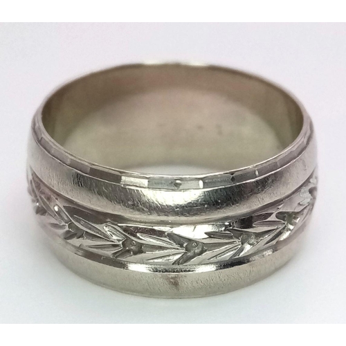 255 - A 14k white gold 9mm wide engraved centre band ring. Size P. 8.3g