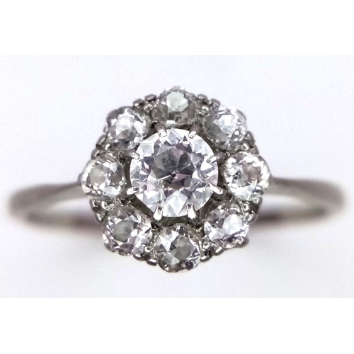 351 - A Vintage 18K Gold and Platinum Diamond Ring. A Central brilliant round cut diamond with eight diamo... 