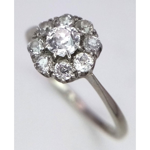 351 - A Vintage 18K Gold and Platinum Diamond Ring. A Central brilliant round cut diamond with eight diamo... 