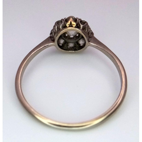 351 - A Vintage 18K Gold and Platinum Diamond Ring. A Central brilliant round cut diamond with eight diamo... 