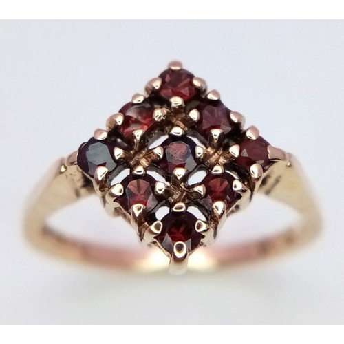 418 - A 9K YELLOW GOLD GARNET SET RING. 2.1G. SIZE K.