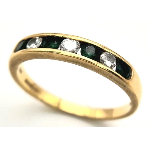 172 - AN 18K YELLOW GOLD DIAMOND & EMERALD BAND RING - 0.15CT DIAMOND & 0.30CT EMERALD. 2.6G TOTAL. SIZE N