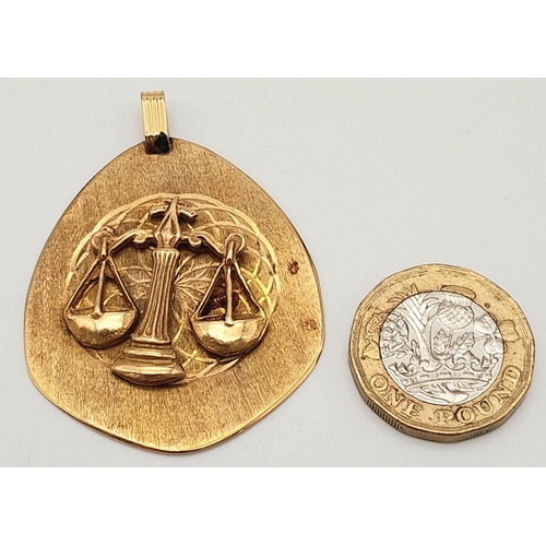 248 - A 10k stamped yellow gold large libra scales pendant. 10.5g. Approximately 5cm by 4cm.