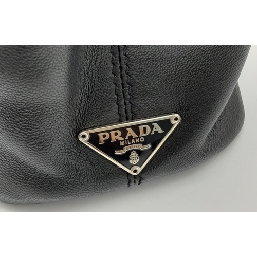 178 - A Prada Wrist Mini Leather Ring Handle Bag. Black nappa leather with maxi ring-shaped handle in silv... 