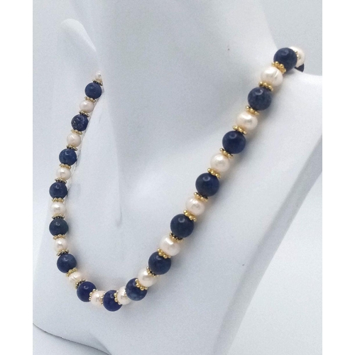 191 - A Lapis Lazuli and Cultured Pearl Matinee Necklace. 8mm beads and pearls. Gilded spacers and clasp. ... 