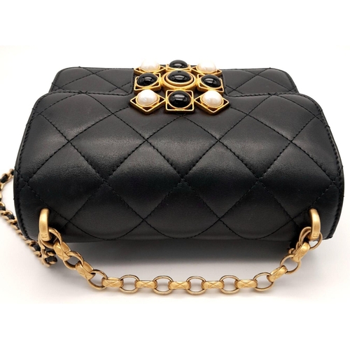 24 - A Chanel Black Mini Flap Bag. Quilted leather exterior with gold-toned hardware, pearl and onyx embe... 