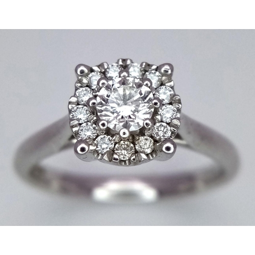 263 - A 9K White Gold Diamond Ring. 0.30ct brilliant round cut centre stone with diamond halo. Size I 1/2.... 