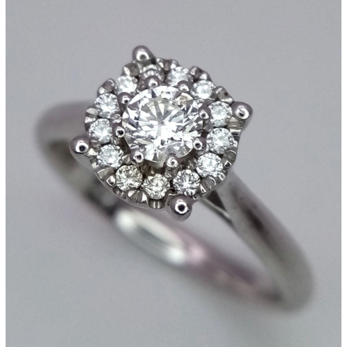 263 - A 9K White Gold Diamond Ring. 0.30ct brilliant round cut centre stone with diamond halo. Size I 1/2.... 