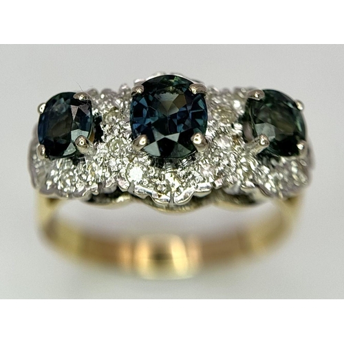 36 - An 18K Yellow Gold (tested) Sapphire and Diamond Ring. Three oval cut sapphires with a twenty-four d... 