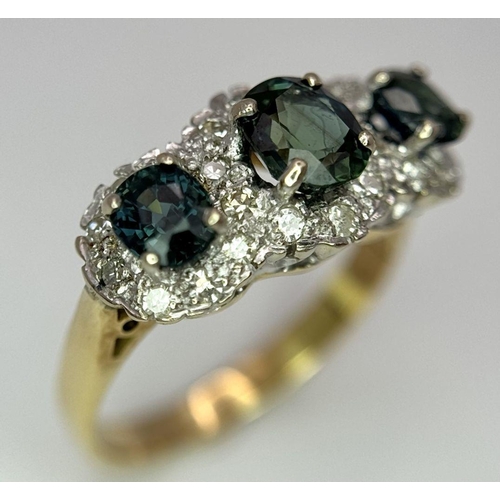 36 - An 18K Yellow Gold (tested) Sapphire and Diamond Ring. Three oval cut sapphires with a twenty-four d... 