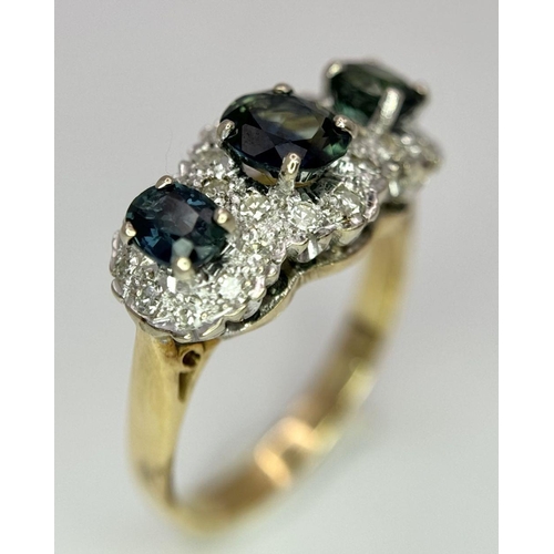 36 - An 18K Yellow Gold (tested) Sapphire and Diamond Ring. Three oval cut sapphires with a twenty-four d... 