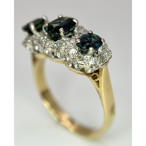 36 - An 18K Yellow Gold (tested) Sapphire and Diamond Ring. Three oval cut sapphires with a twenty-four d... 