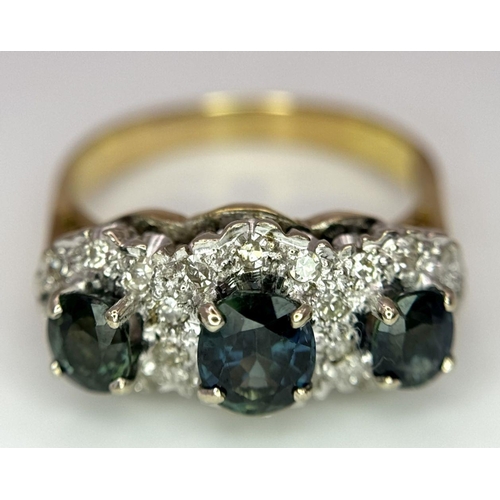 36 - An 18K Yellow Gold (tested) Sapphire and Diamond Ring. Three oval cut sapphires with a twenty-four d... 